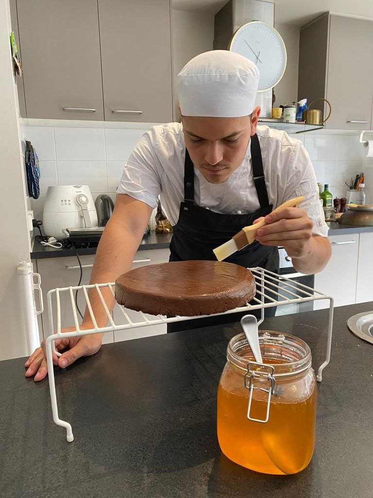 David glazing a chocolate cake with honey