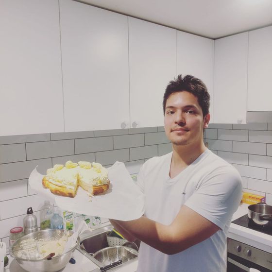 David holding a lemon tart in a small home kitchen